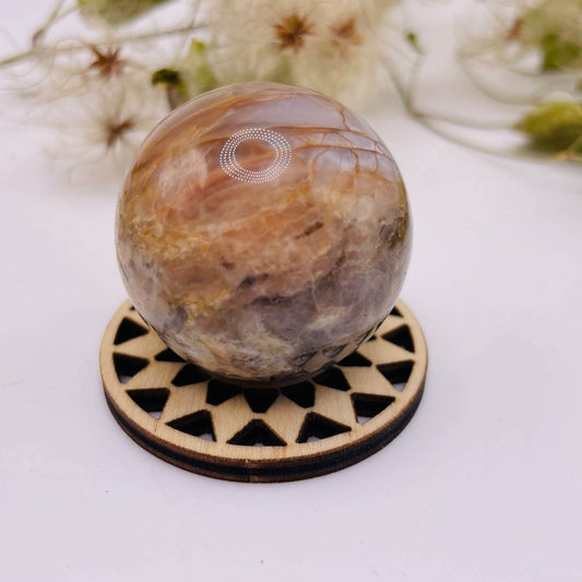 Peach-Mondstein-Kugel mit ca. 40 mm Durchmesser in Pfirsich-, Creme- und Grautönen auf einem Holzständer – Unikat von WUNDERSTEIN.
