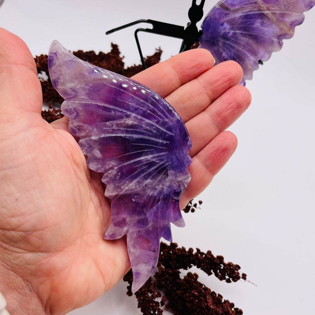 Draufsicht auf den handverlesenen Amethyst-Schmetterling von WUNDERSTEIN: violette Flügel mit natürlicher Maserung auf Metallständer
