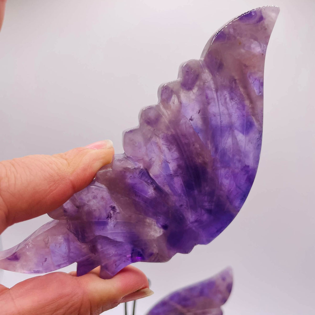 Nahaufnahme der aus Amethyst gearbeiteten Schmetterlingsflügel mit lila-weiß gebänderter Struktur und fein ausgearbeiteten Flügeladern

