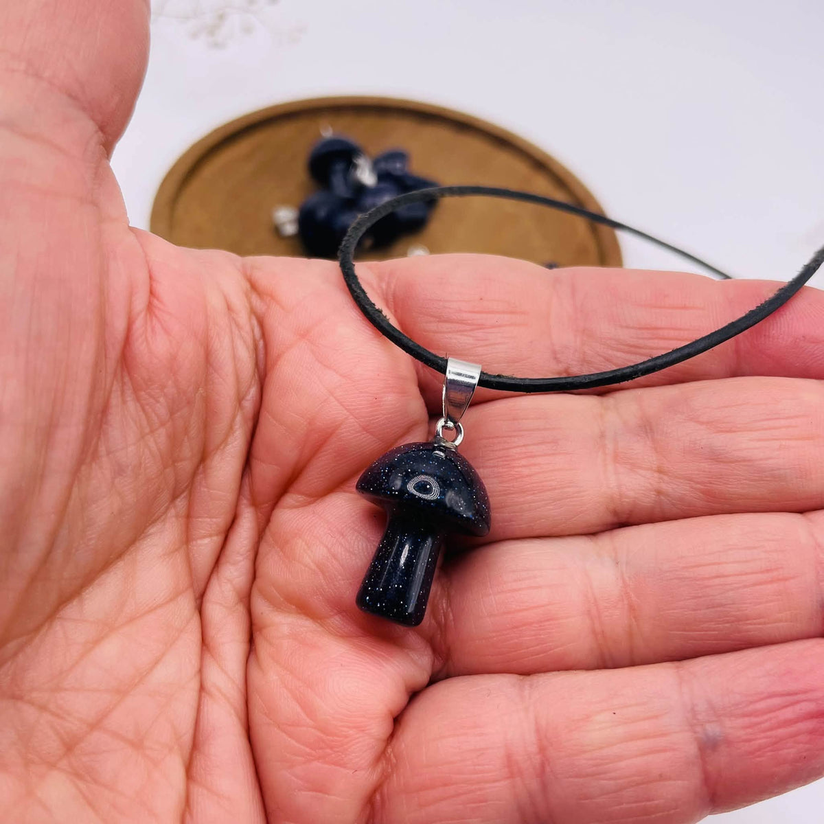 Nahaufnahme des funkelnden Blauflusses am kleinen Glückspilz-Anhänger mit Silberöse
