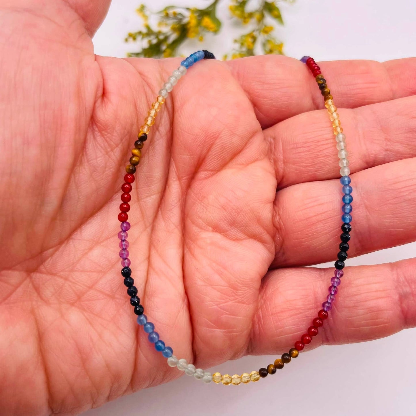 Hauchzarte Regenbogen Halskette in der Hand – Edelsteinperlen 2 mm, Amethyst, roter Achat, blauer Achat – WUNDERSTEIN
