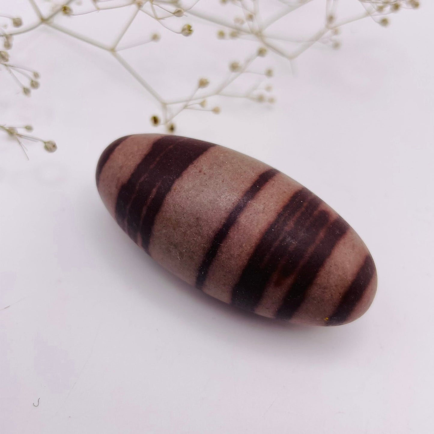 Shiva Lingam Unikat Nr. 12 – charakteristische rote Muster, natürlich geformt, Seitenansicht | WUNDERSTEIN
