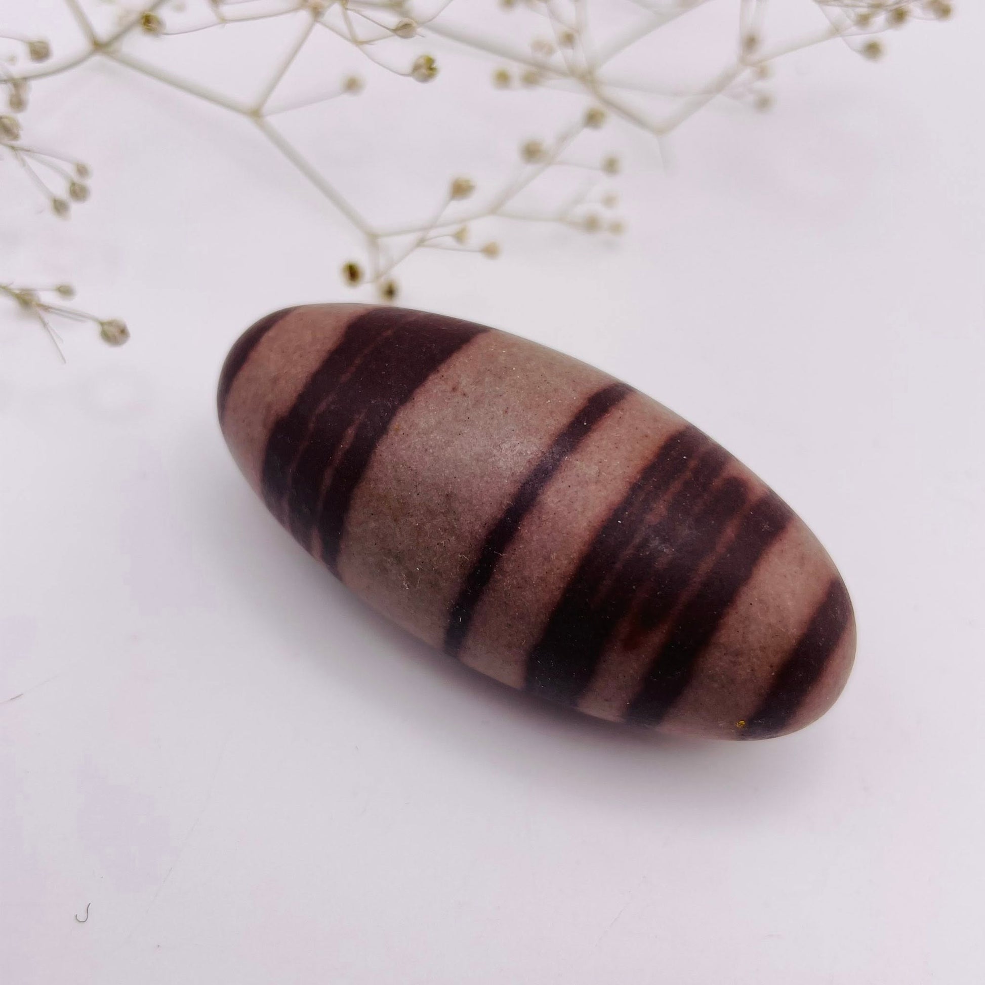 Shiva Lingam Unikat Nr. 12 – charakteristische rote Muster, natürlich geformt, Seitenansicht | WUNDERSTEIN
